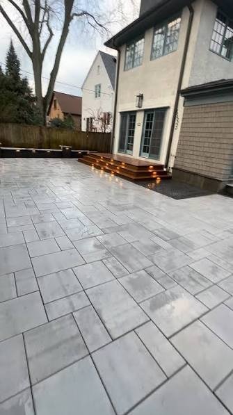 Large-format paver patio with lit deck steps