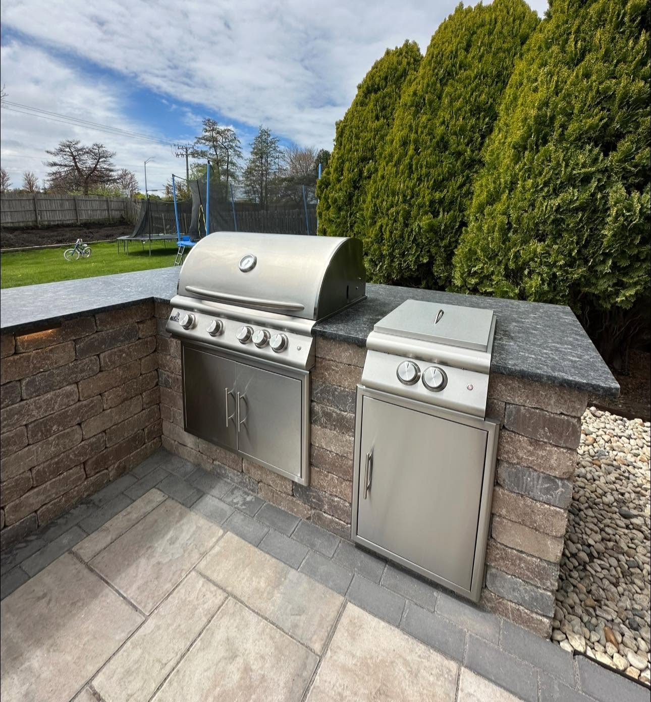 Outdoor kitchen with built-in grill, side burner and stone countertop