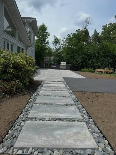 Large stepping stones set in river rock leading to a patio